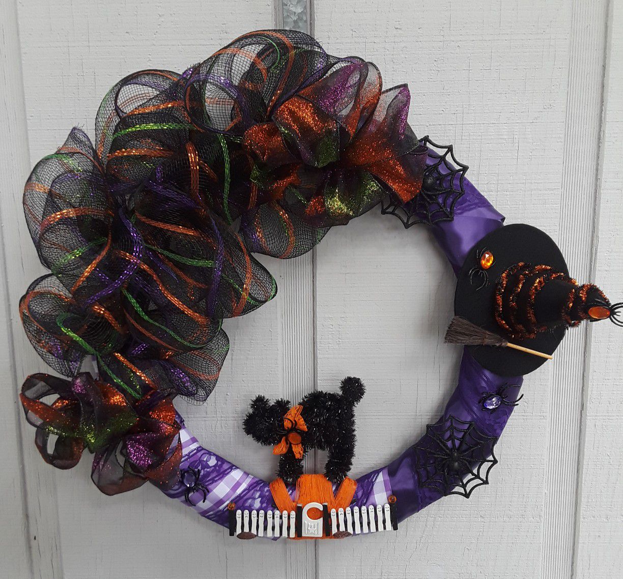 Halloween wreath. Purple ribbon, deco mesh black cat, spiders and witches hat door decoration
