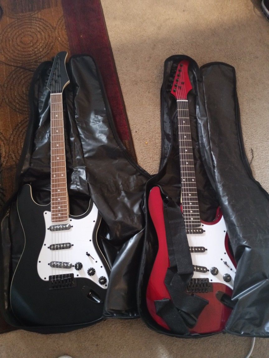 X 2 Kids Guitars. 1 Red 1 Black X2 Amps X2 Guitar Bags X2 Shoulder Straps