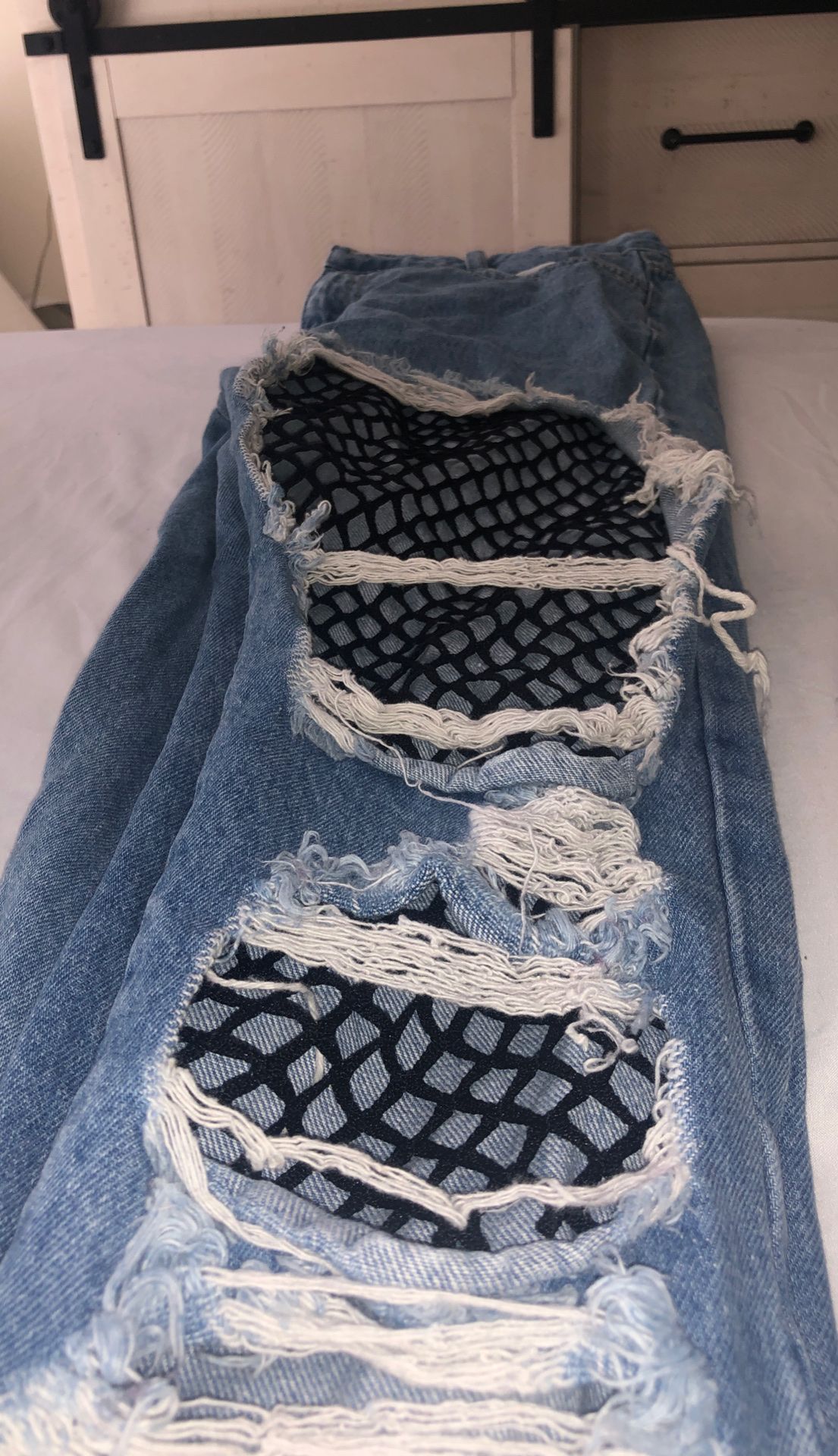 Distressed jeans with fishnet stockings