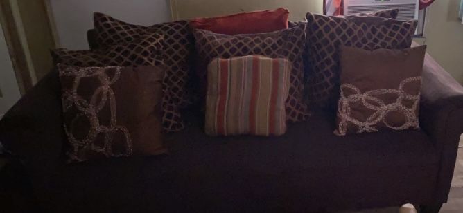 A two-piece chocolate living room Set With two lamps three tables and a rug