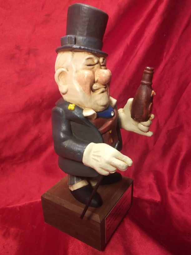 WC Fields figurine with cane, Maker's Mark Kentucky Whiskey 1972
On a genuine teak wood base with cigar beer cane and top hat and it reads ...
