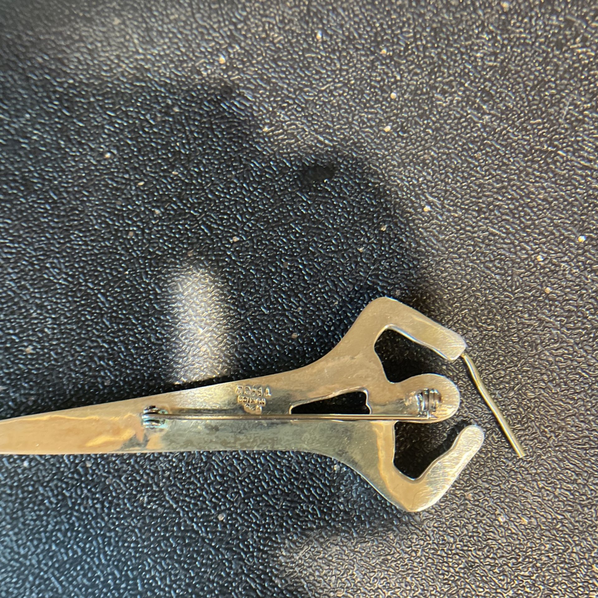 Silver 4 1/4 inch pin, it’s an orchestra conductor