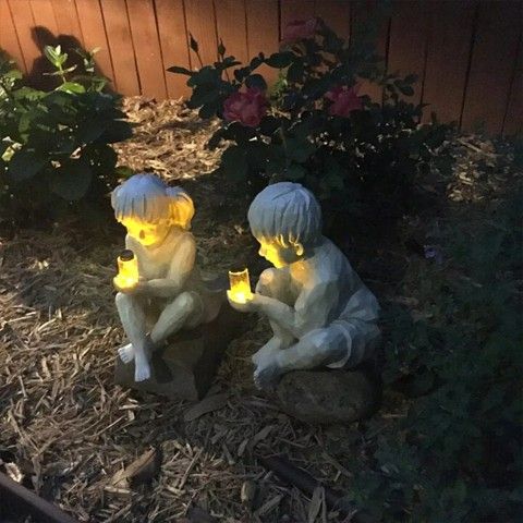 Creatively Statues Of 2 Kids Holding Fireflies.