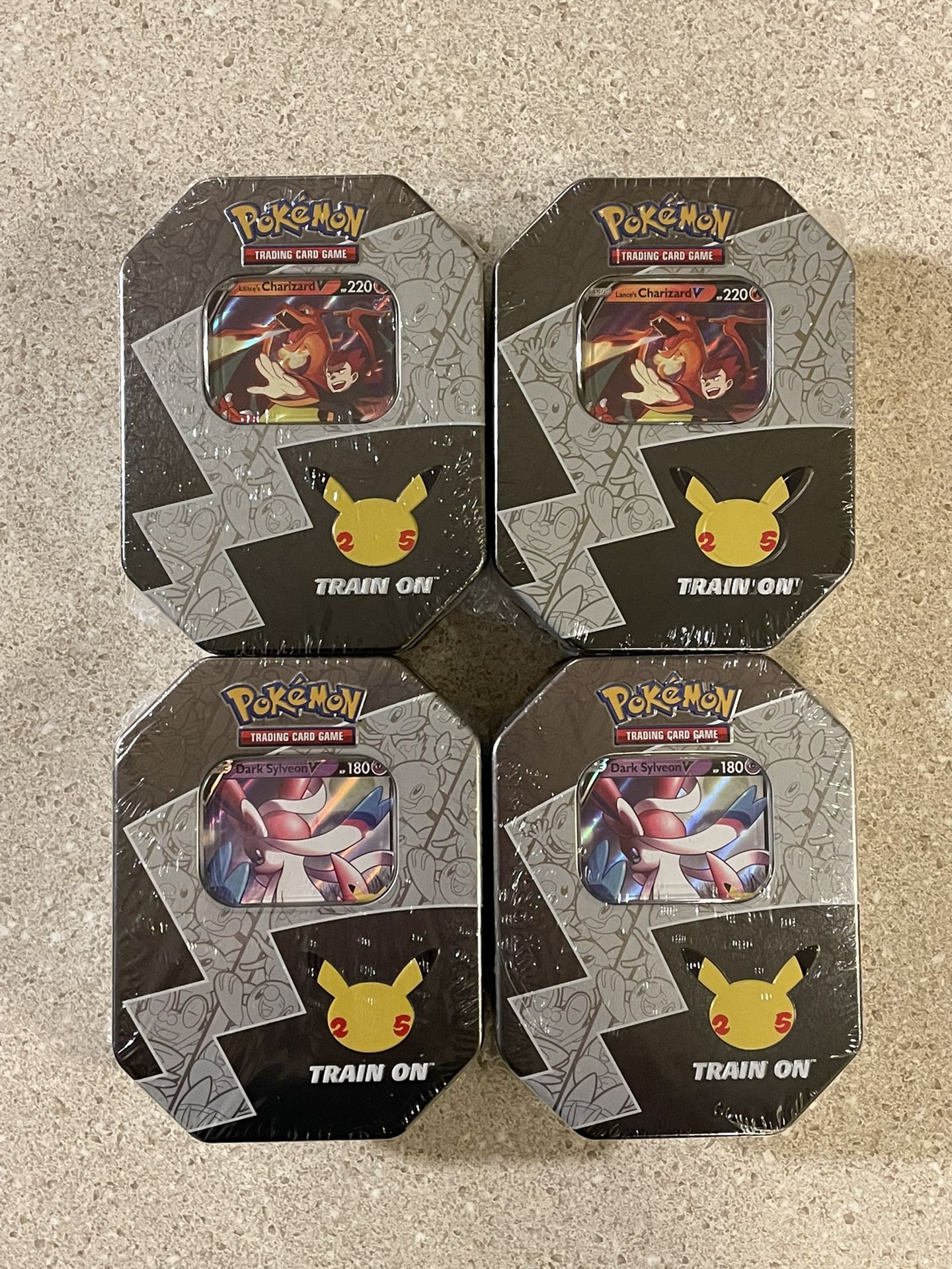 Pokémon 25th Anniversary Celebrations Collector’s Tins - Lance’s Charizard V & Dark Sylveon V