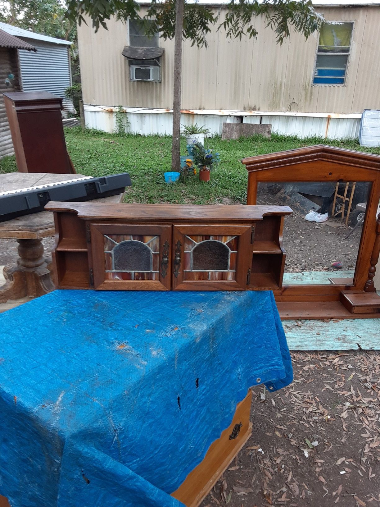 A little Oak cabinet with two shelves on each side and stained glass doors in the front