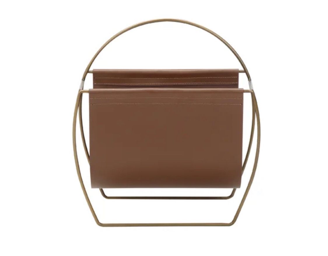 Hardage magazine rack by Mercury Row. Overall: 23” H x 22” W x 10” D. Faux leather. MSRP: $300. Our price: $95 + Sales tax