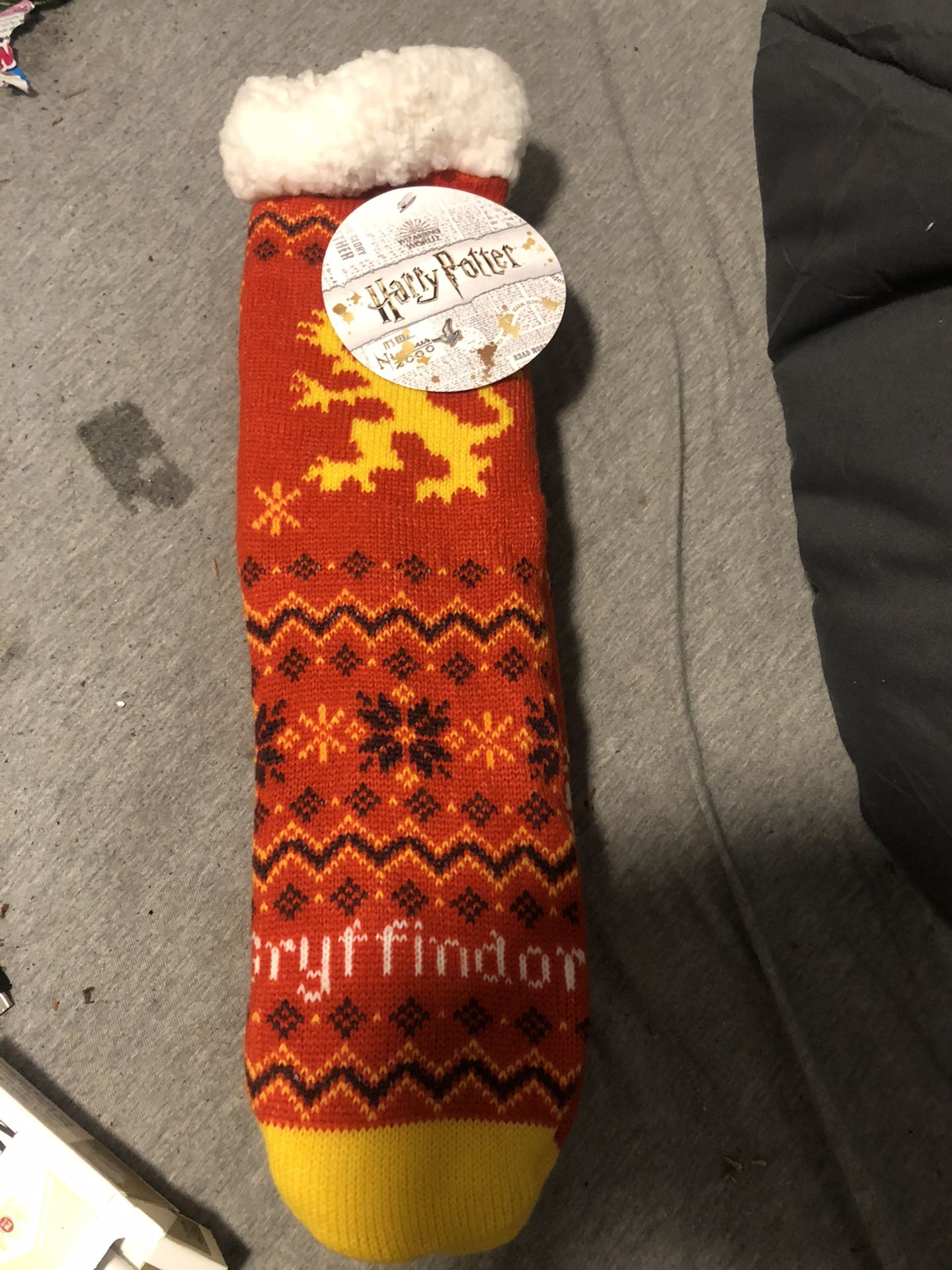 Harry Potter one size fits ok gryffondor house with the logo at the bottom . With the lion in the middle never worn selling for less than half retail