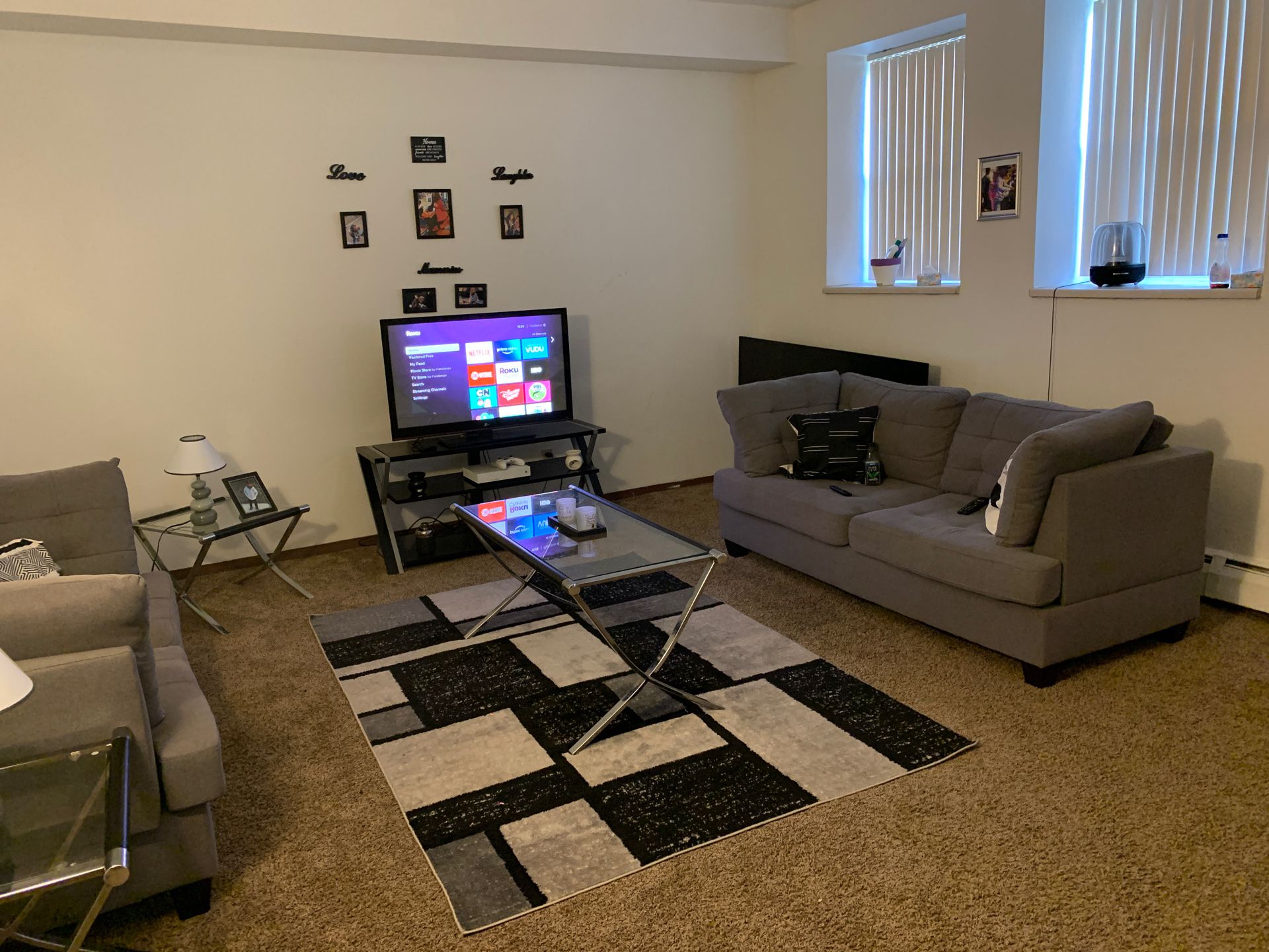 Living room set , with one couch , end tables , rug , tv and stand .
