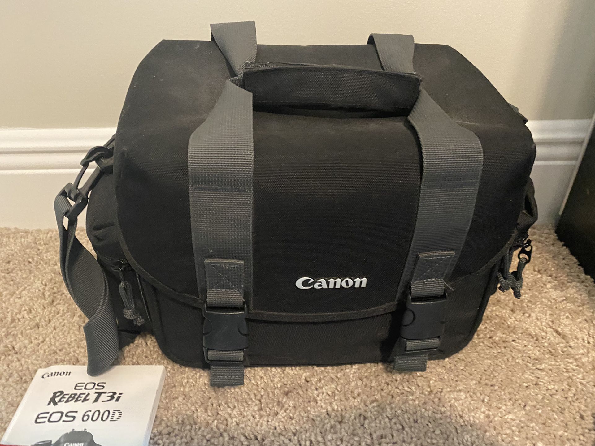 Excellent condition Canon EOS Rebel camera with two lenses, battery charger, and large camera bag.